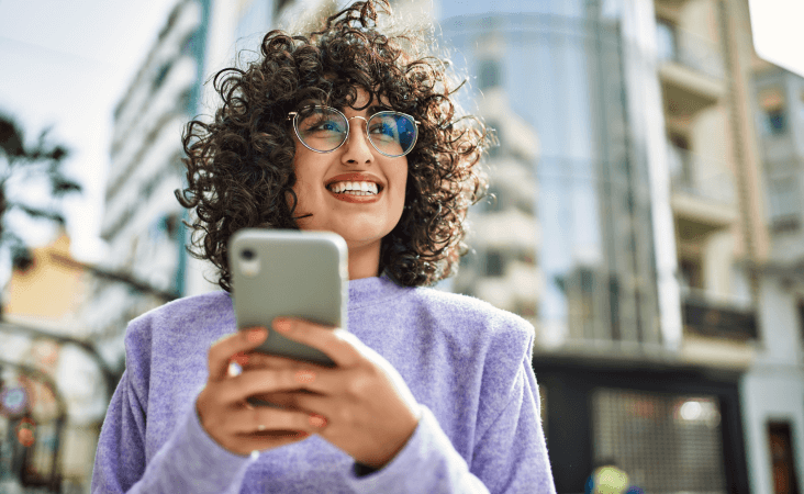 Woman smiling while holding mobile phone