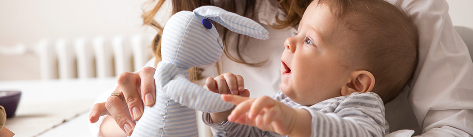 Baby holding doll