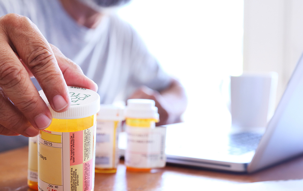 Man holding medication prescription containers