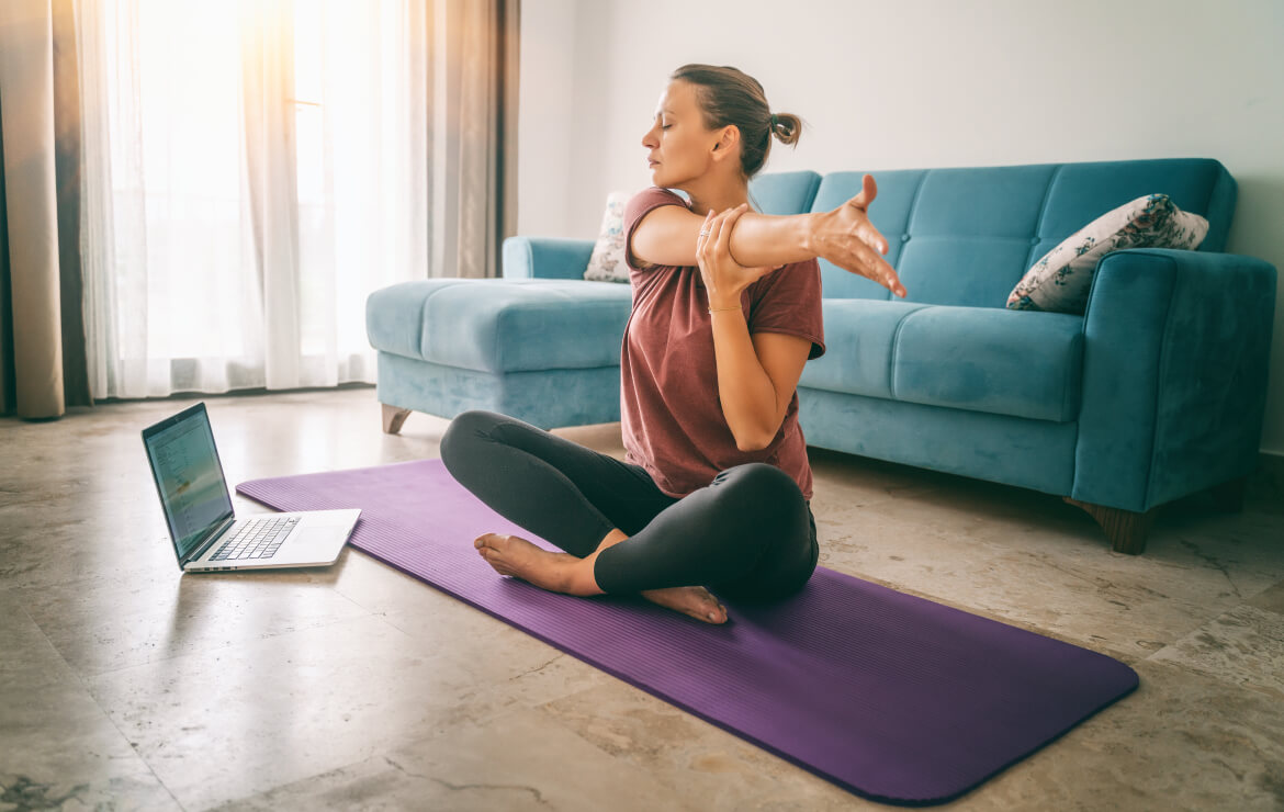 https://www.sharphealthplan.com/images/default-source/site-images/hero-images/woman-sitting-on-yoga-mat-stretching-out-arm_1170x740.jpg?sfvrsn=8076a080_1