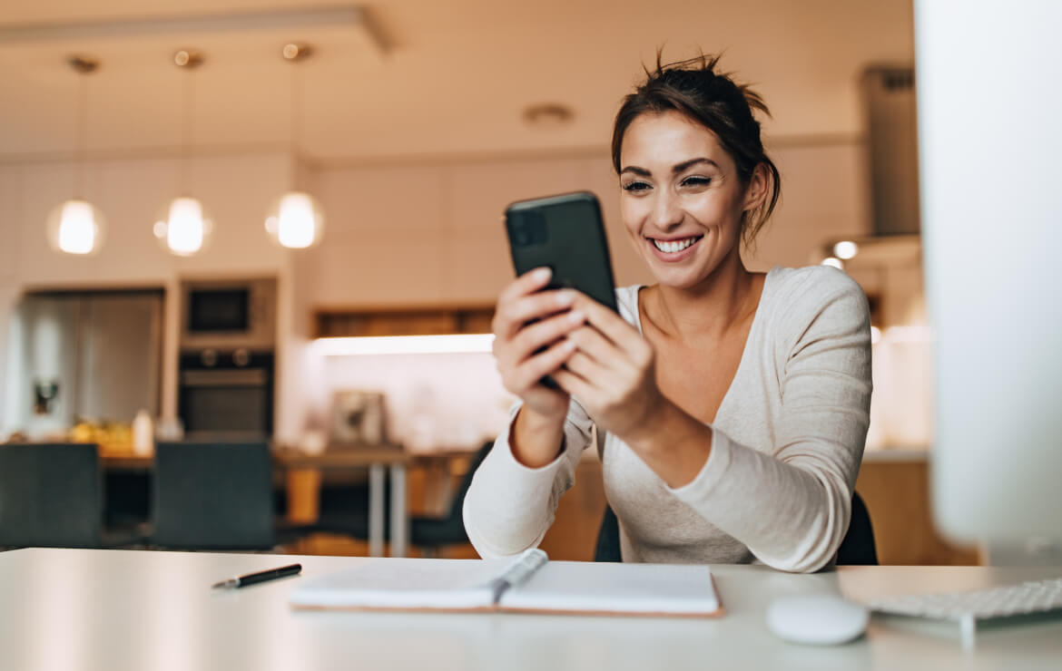 Woman smiling while holding mobile phone