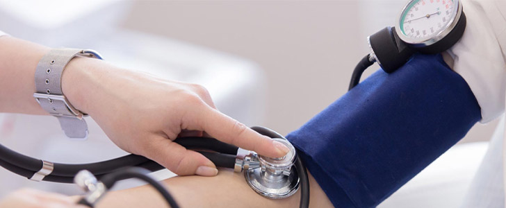 Doctor taking patient's blood pressure and listening to pulse