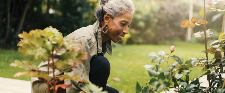 Older woman tending to garden outside