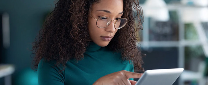 Young woman scrolling on tablet