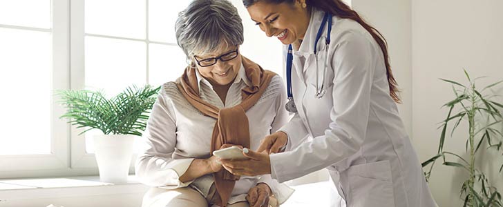 Doctor instructing patient how to use mobile app