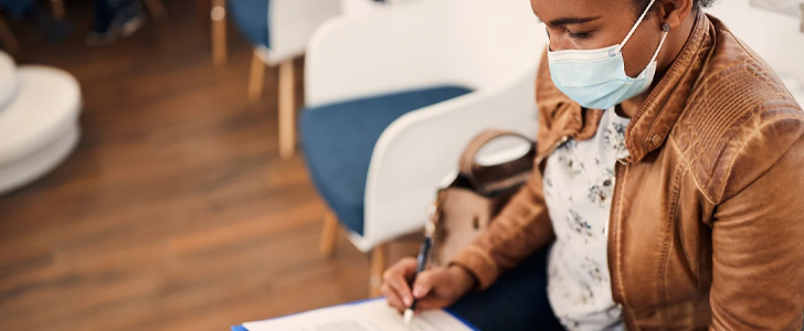 Woman wearing mask filling out form