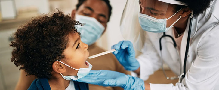 Doctor conducting child wellness exam