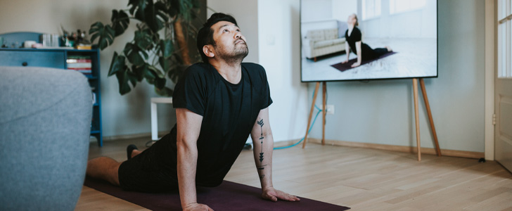 Man practicing yoga pose in living room