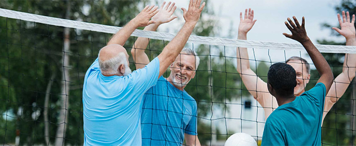 Group of older men playing volleyball together