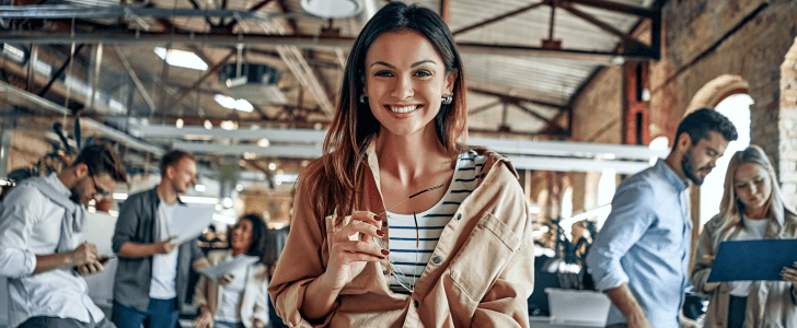 Woman smiling in front of co-workers at the office